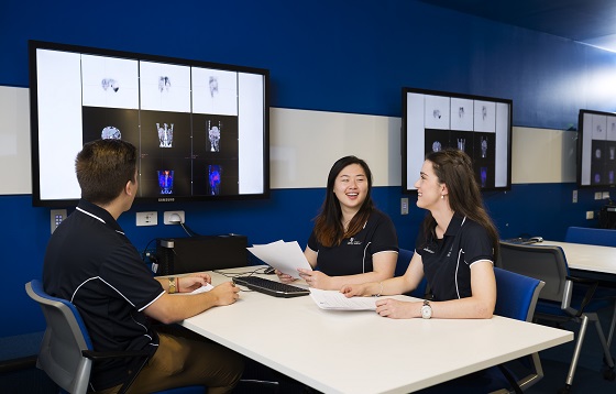 Three students are discussing X-ray images.